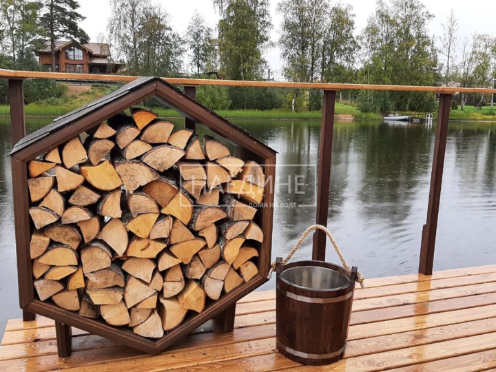 Дровница на террасе плавучей бани – красивый и практичный аксессуар