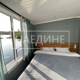 Удобная двуспальная кровать в хаусботе с постельным бельем и видом на воду | Наедине - дома на воде
