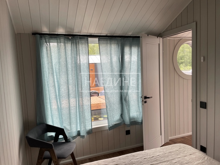 Уютная спальня в арендуемом хаусботе с видом на воду